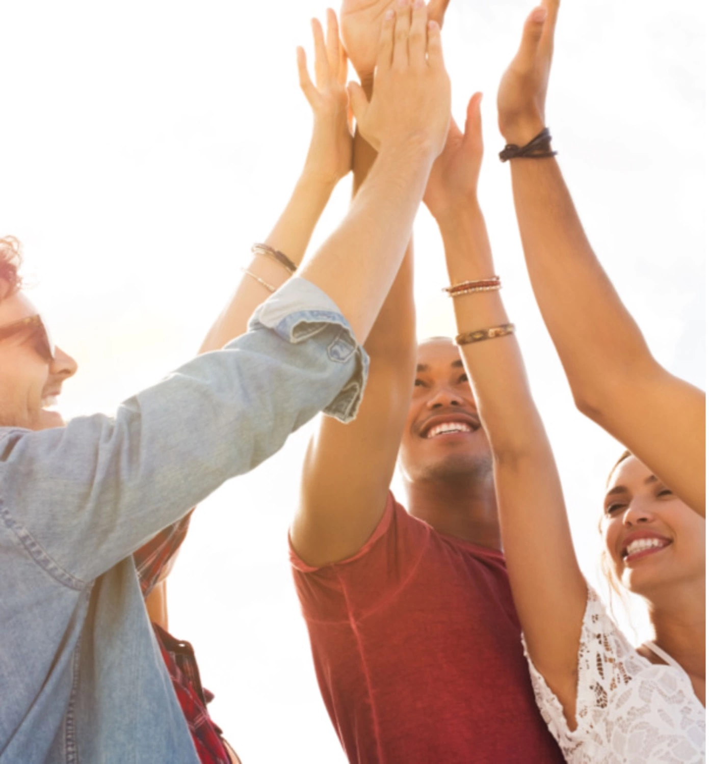 group of young people clapping hands together