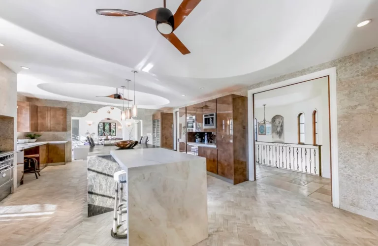 Modern kitchen at Legacy's Los Angeles rehab with light stone floors and counters and wood cabinet accents