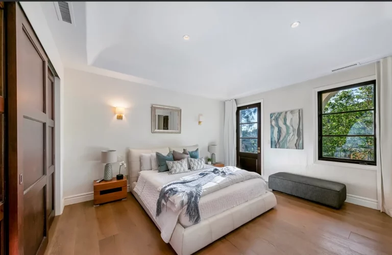 Bedroom at Legacy Healing's drug and alcohol rehab in Los Angeles, complete with bed, closet, and views of the trees outdoors