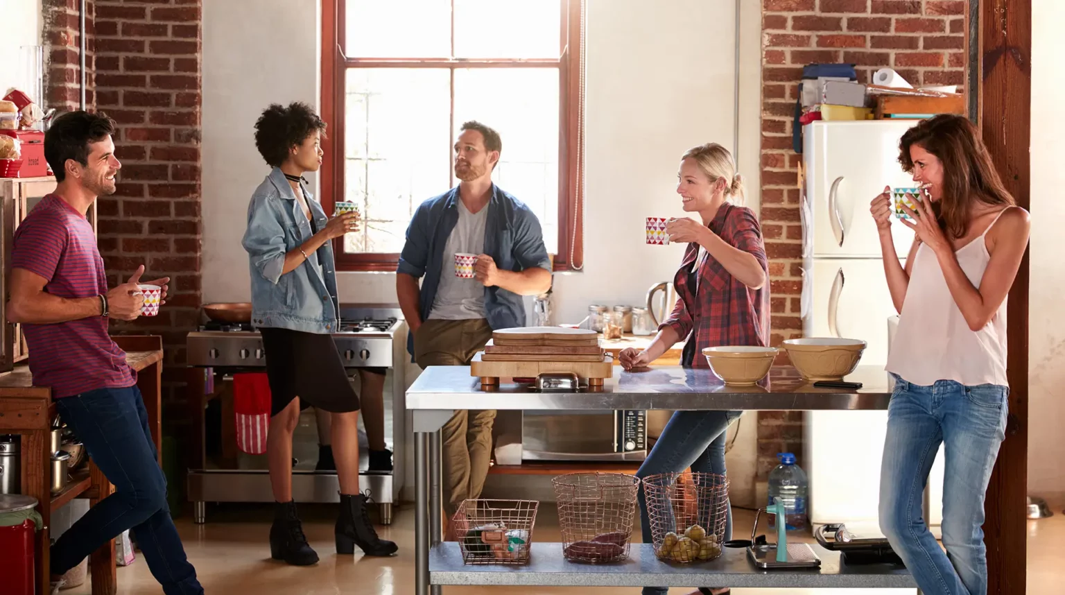 Group of young adults at inpatient rehab have a friendly conversation in the kitchen